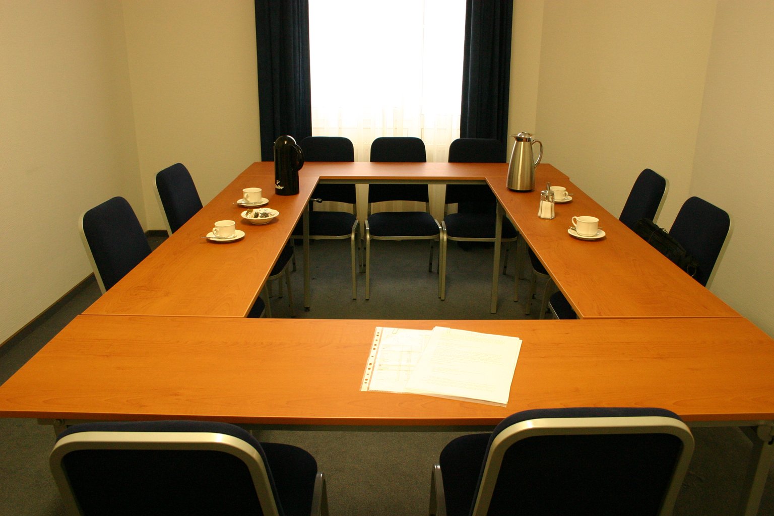 a room set up with multiple conference table and chairs