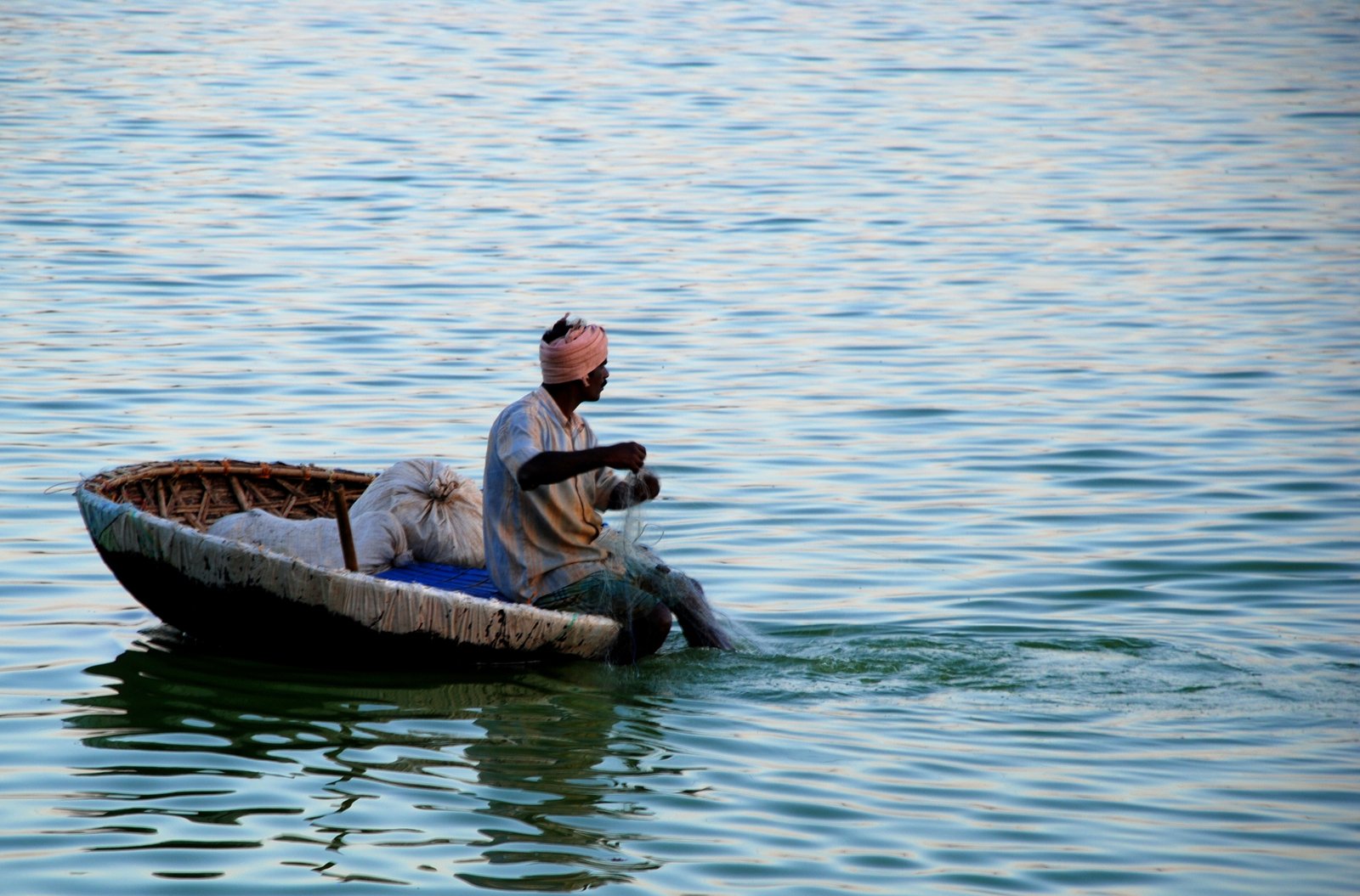 a man sitting on a small boat in the water