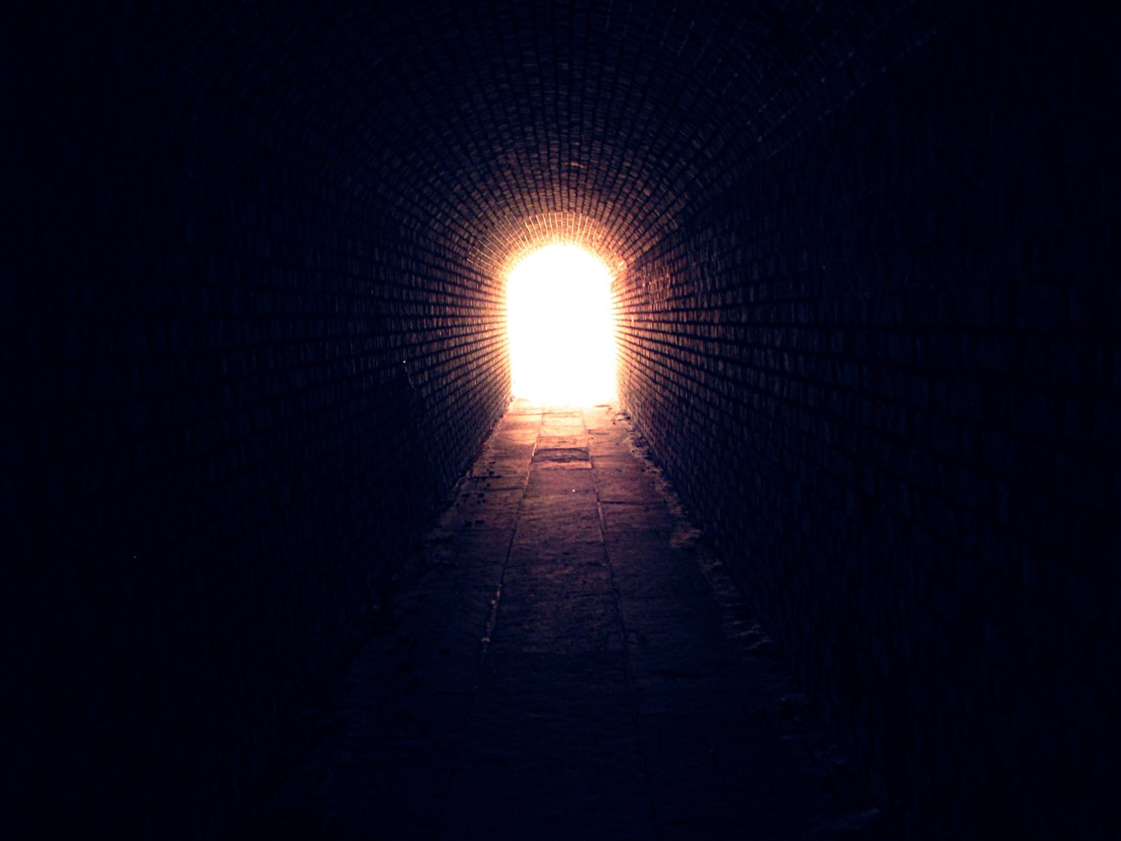 a tunnel going into the distance with light coming from the end