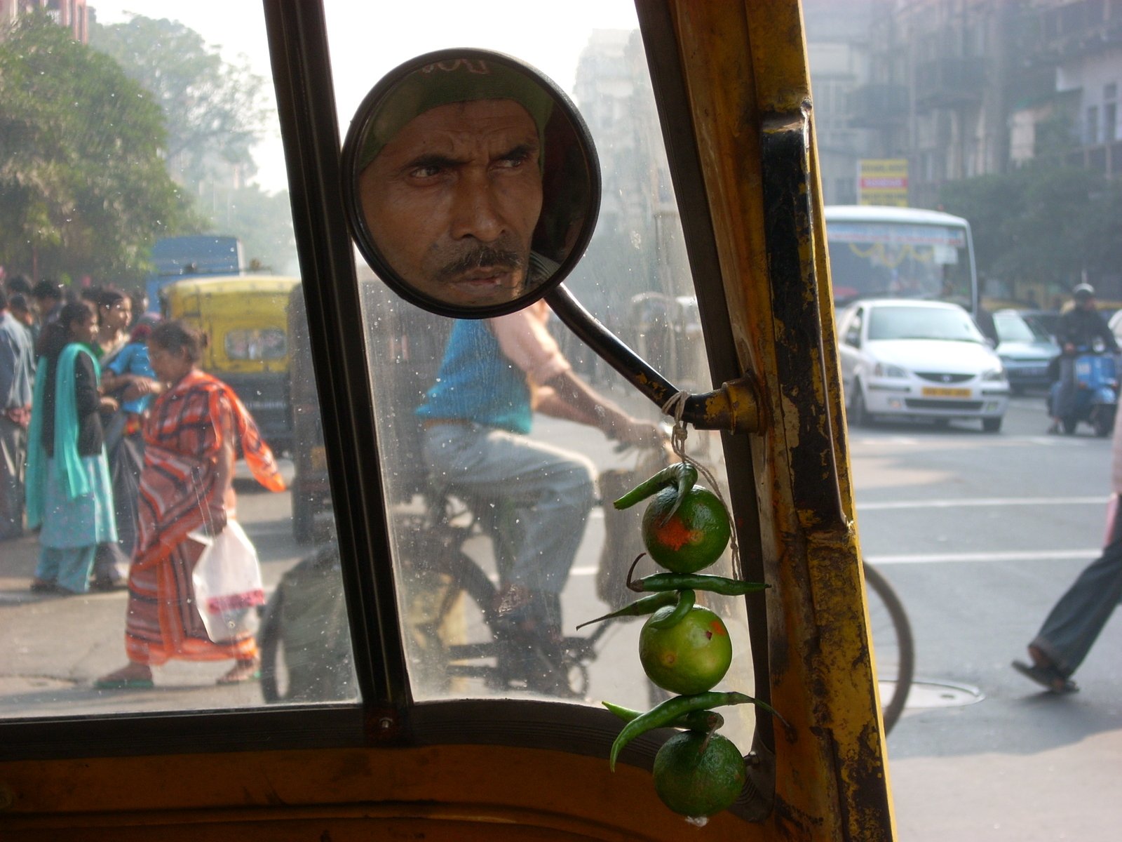 the back view mirror is showing a man riding a bike