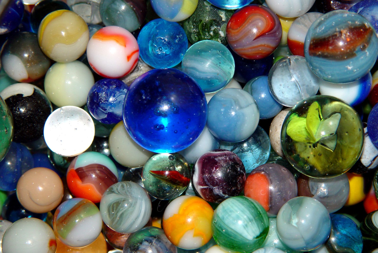 marbles with different colors and shapes are piled high