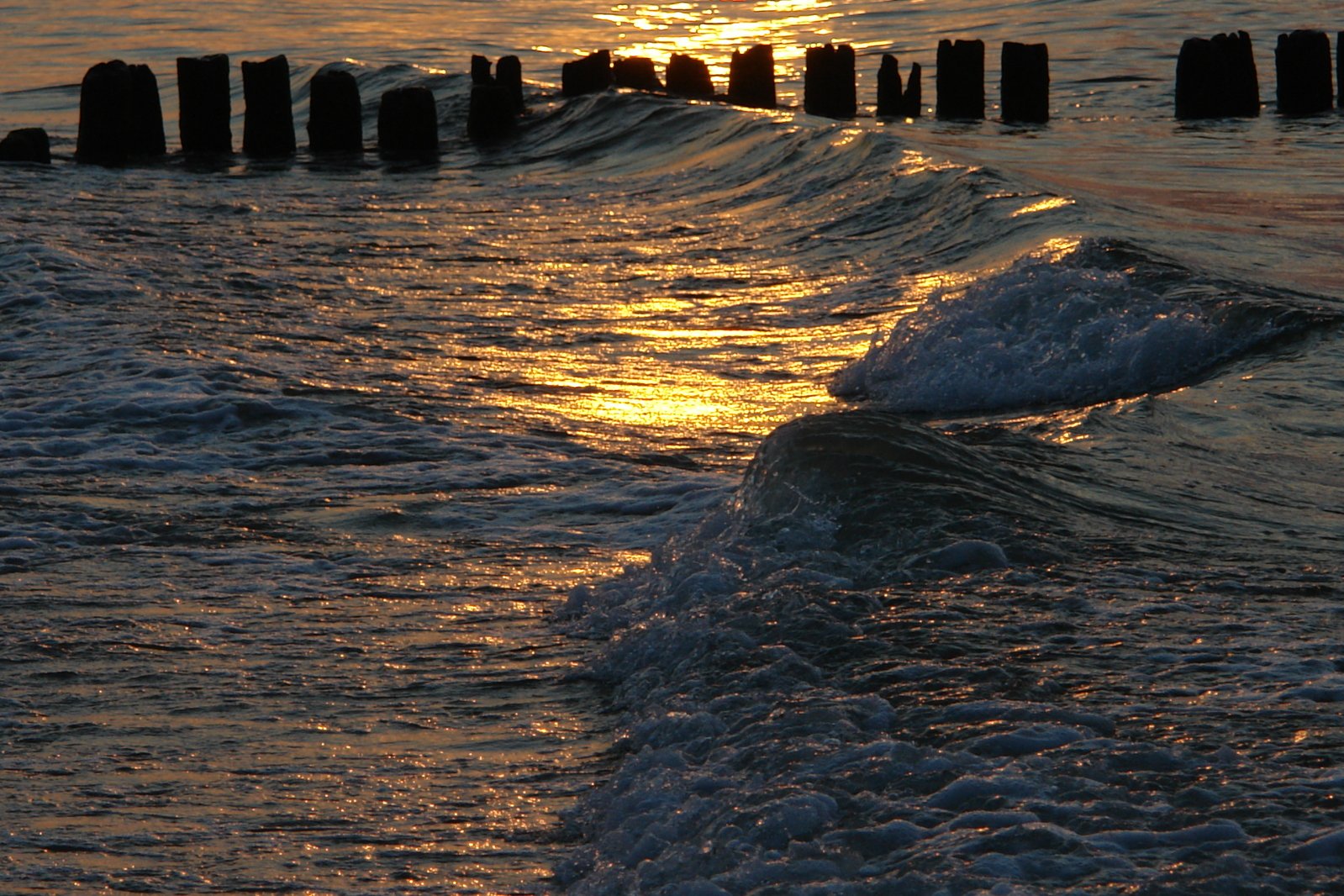 the waves come in to shore as the sun sets