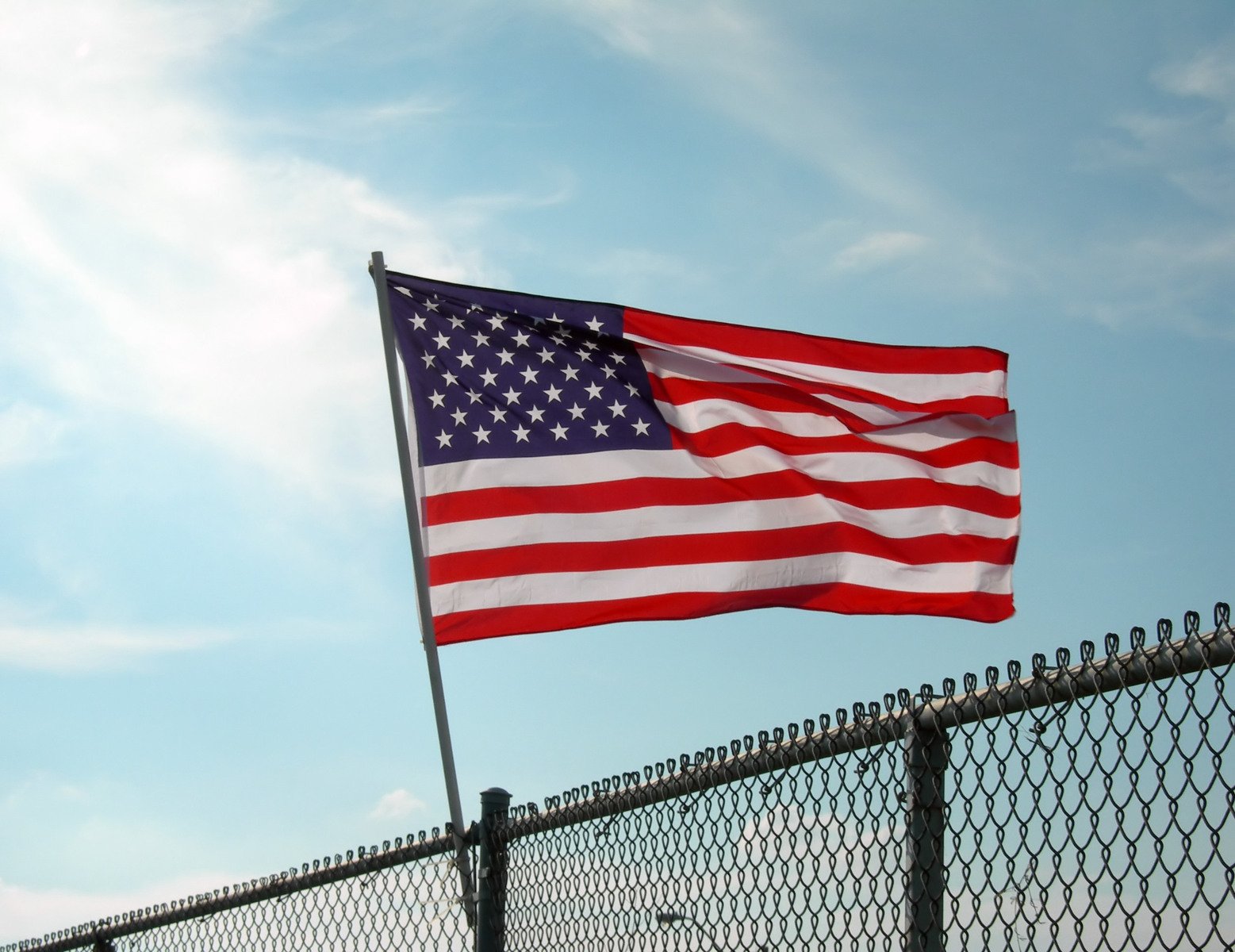 an american flag is on top of the fence