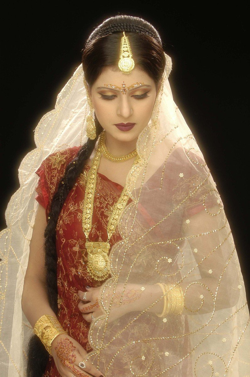 a woman wearing gold jewelry and a red dress