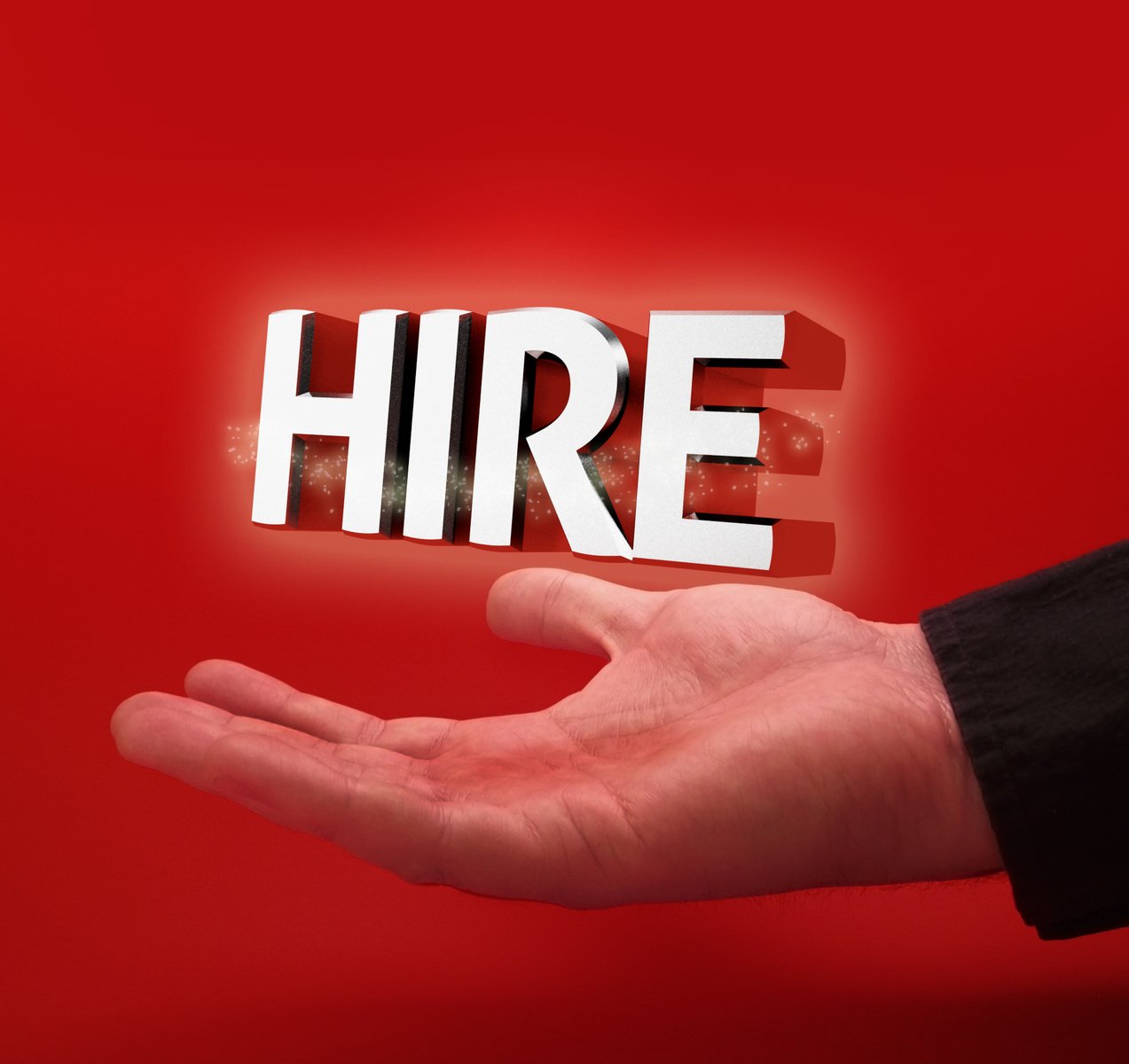 the person holds up the word hire above them