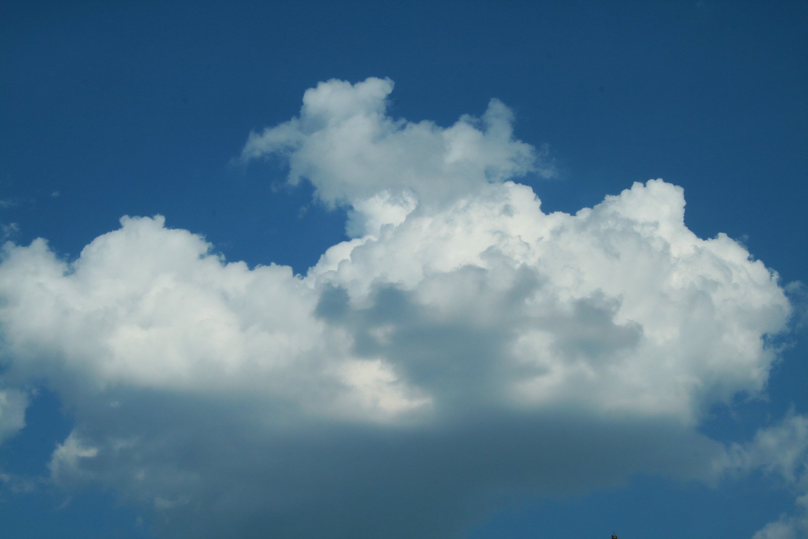 two airplanes are flying under clouds in a blue sky