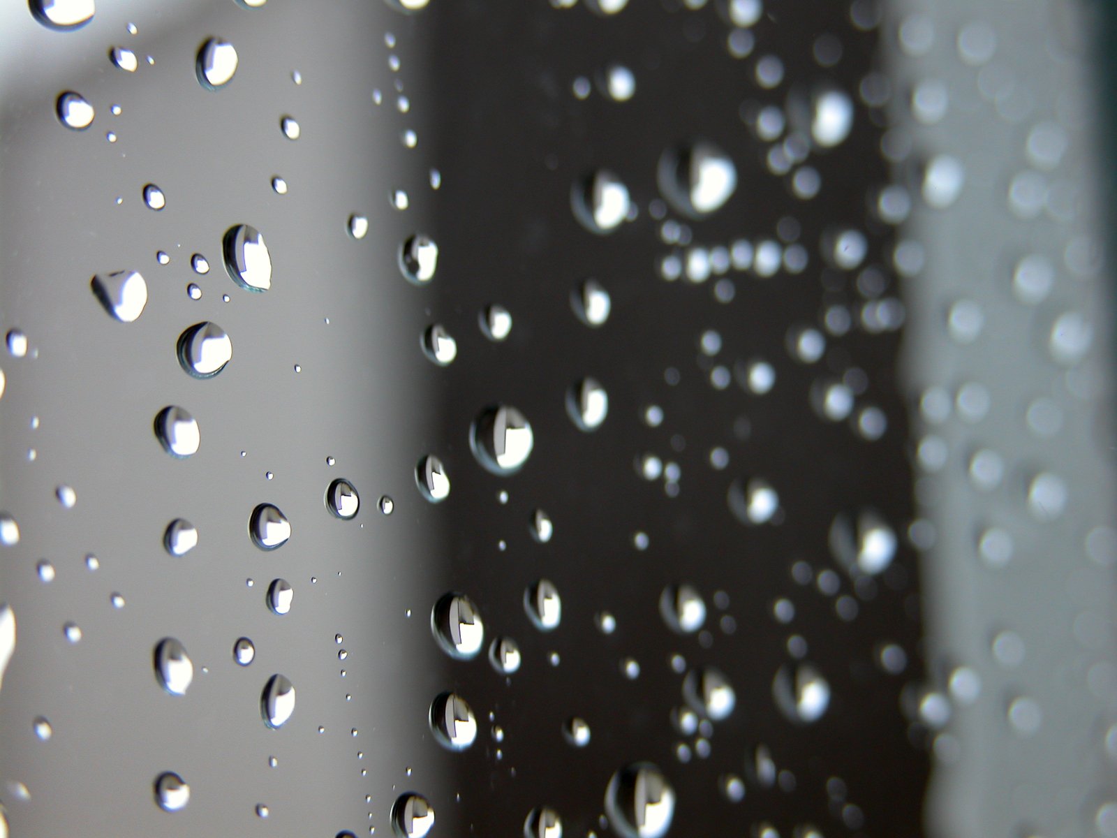 a rain covered window with a white building in the background