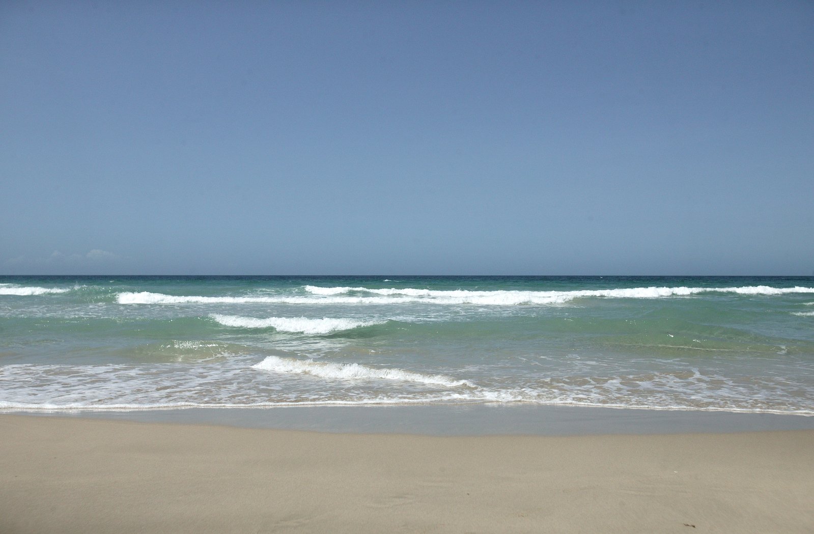 the beach is covered by several gentle waves