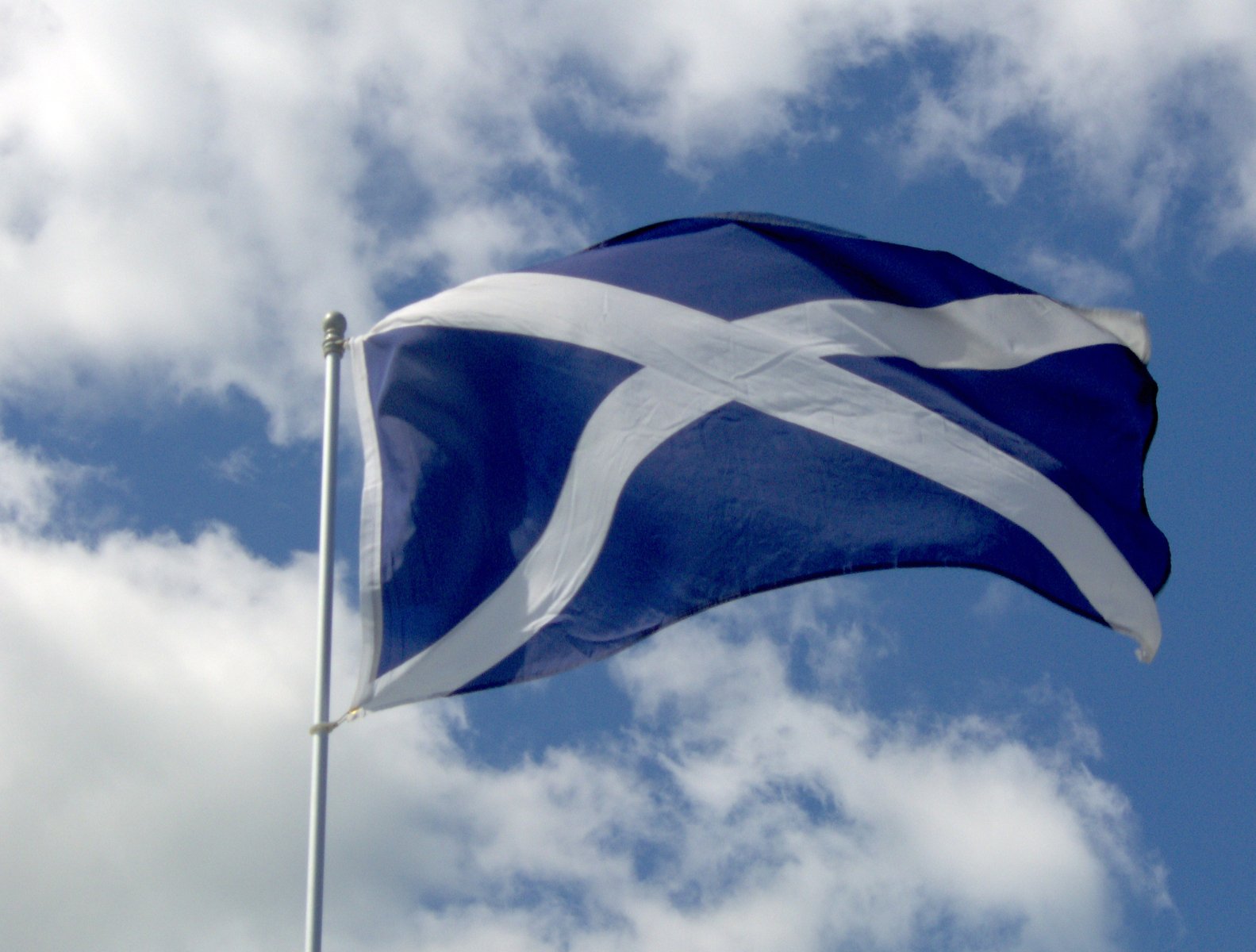 a flag flying in the wind on top of a pole