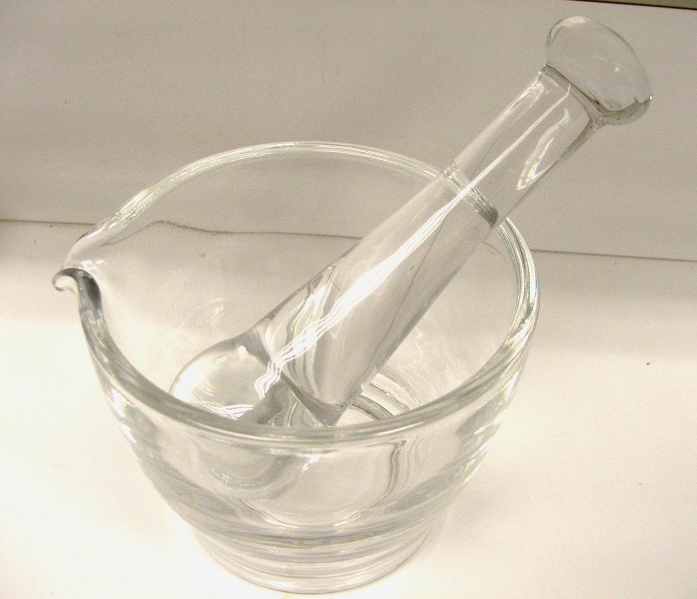 a glass filled with a clear liquid next to a bottle