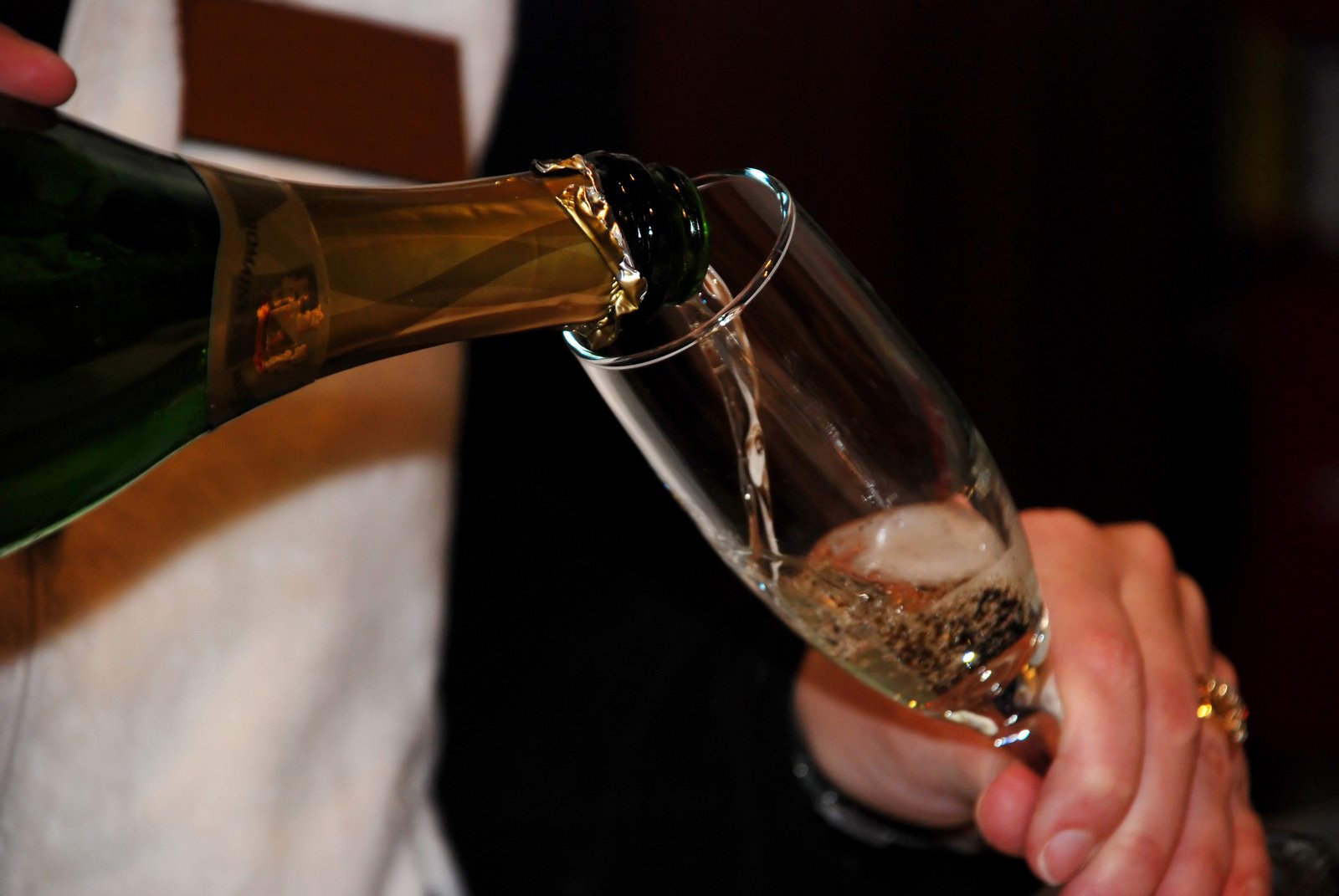 the man pours beer into a wine glass