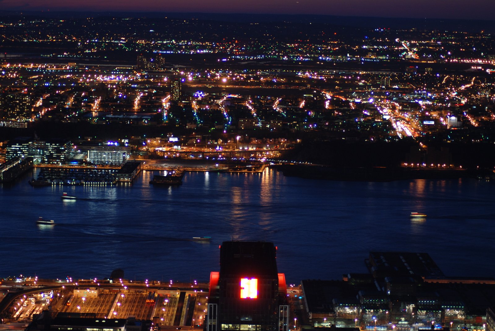 an aerial view of city lights and river at night