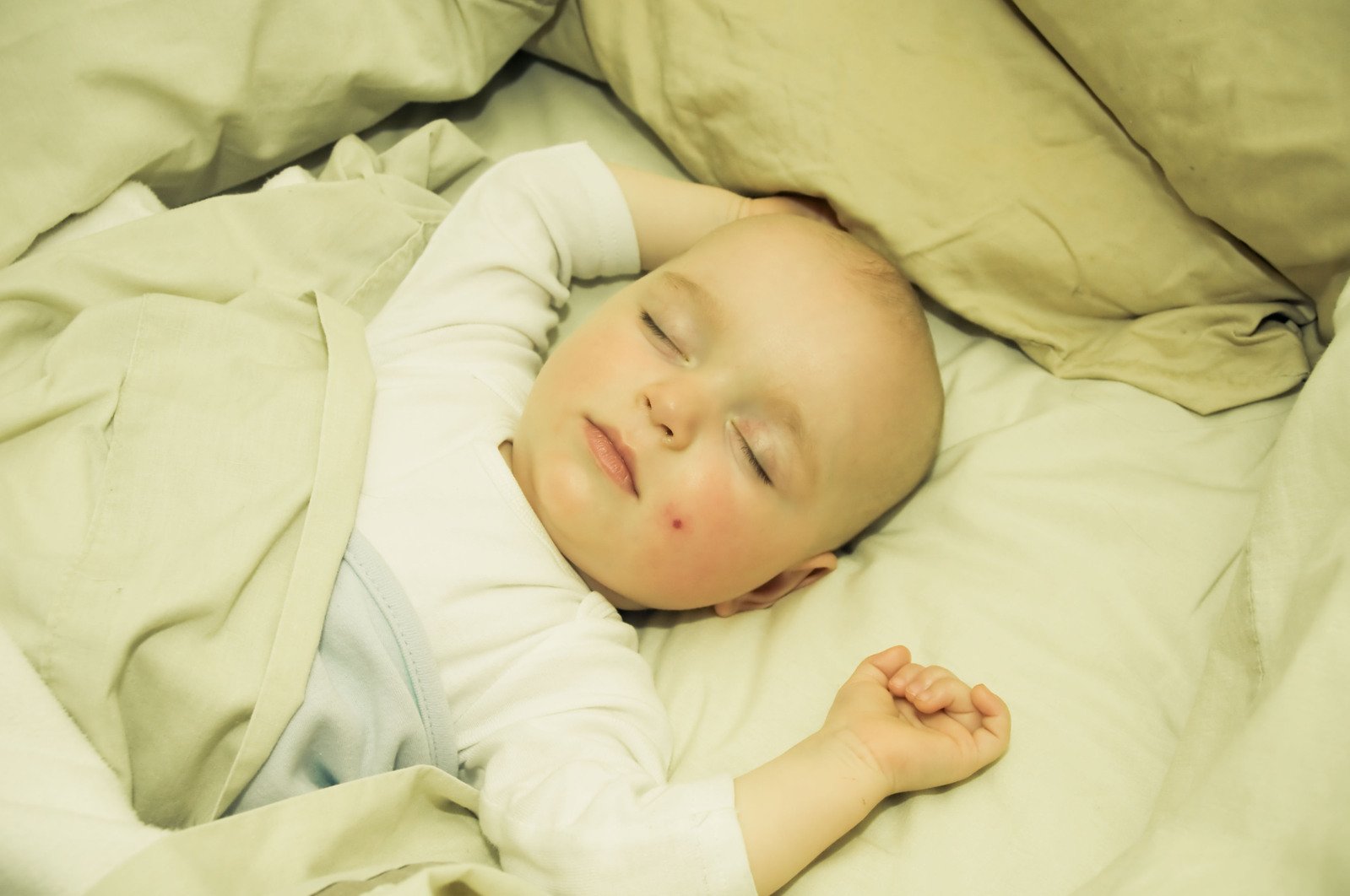 a baby is sleeping on top of a white bed