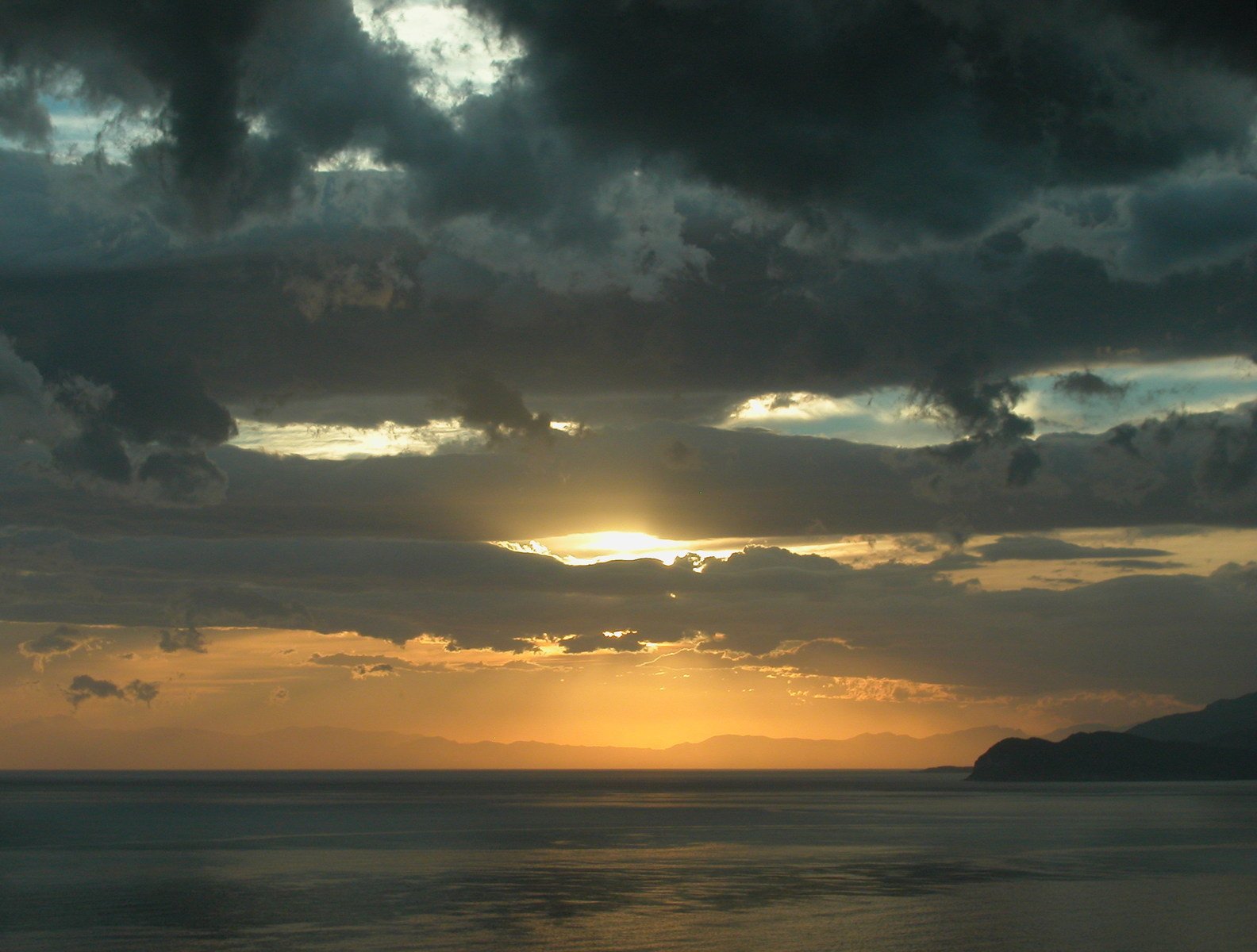 a large body of water at sunset on the horizon