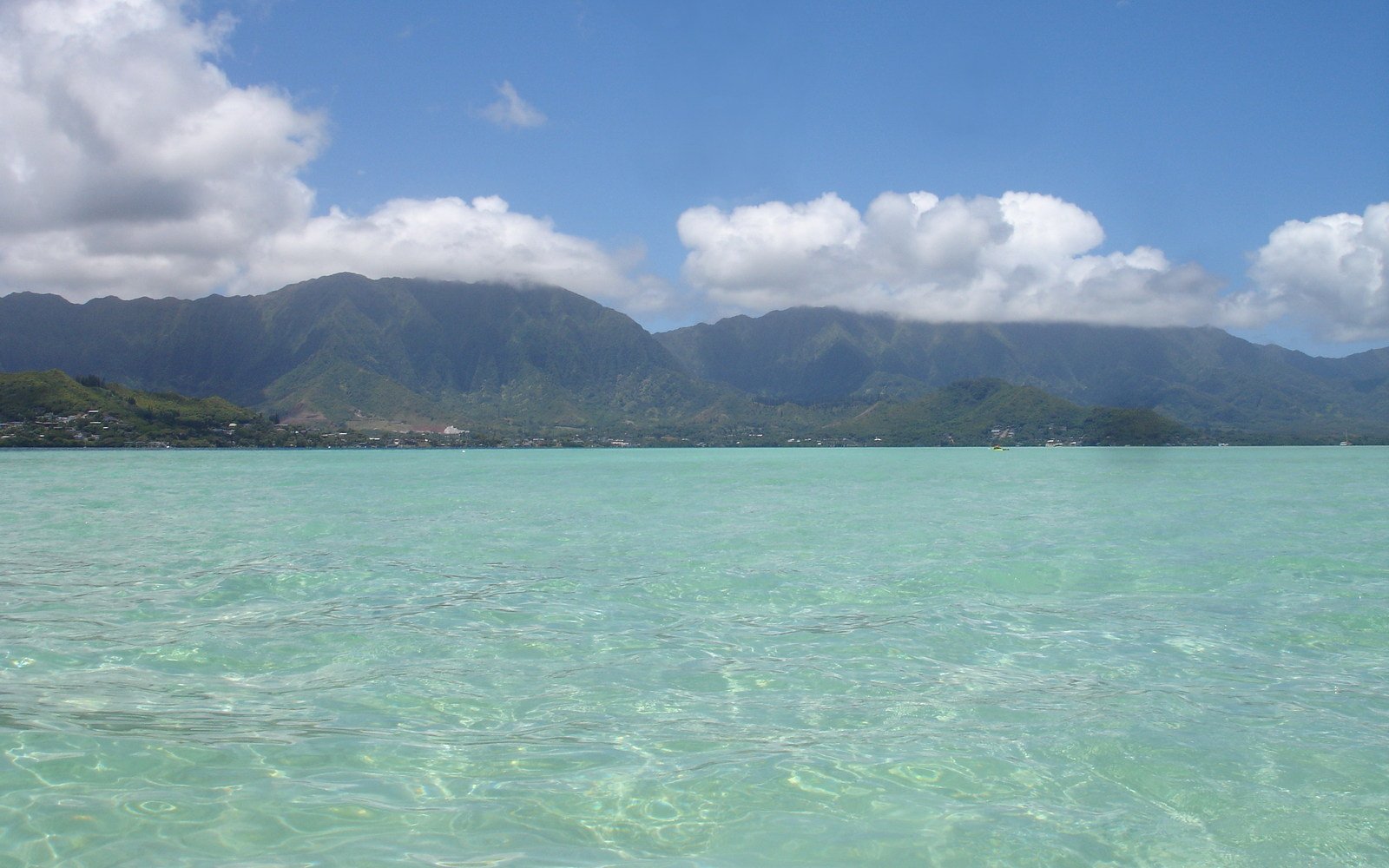 the clear water looks as it reflects a landscape with mountains