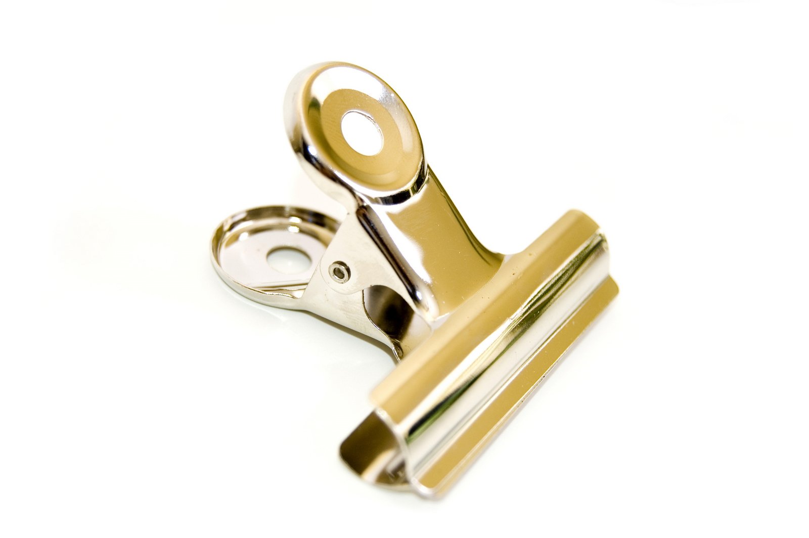 a gold colored safety clip with a white background