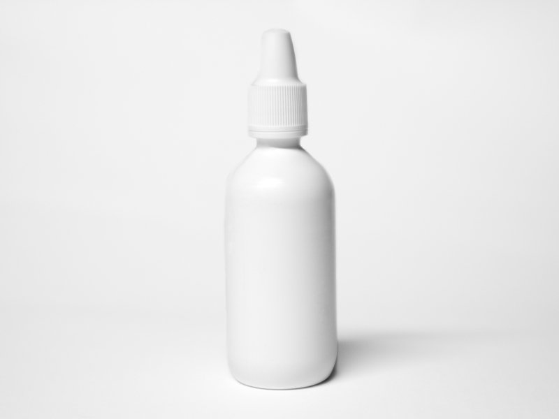 white plastic bottles with caps are lined up against a white backdrop