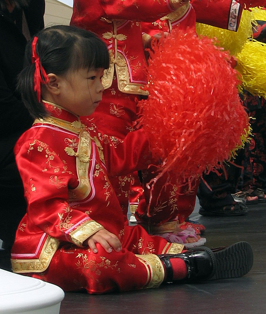 a little girl dressed in red is kneeling down