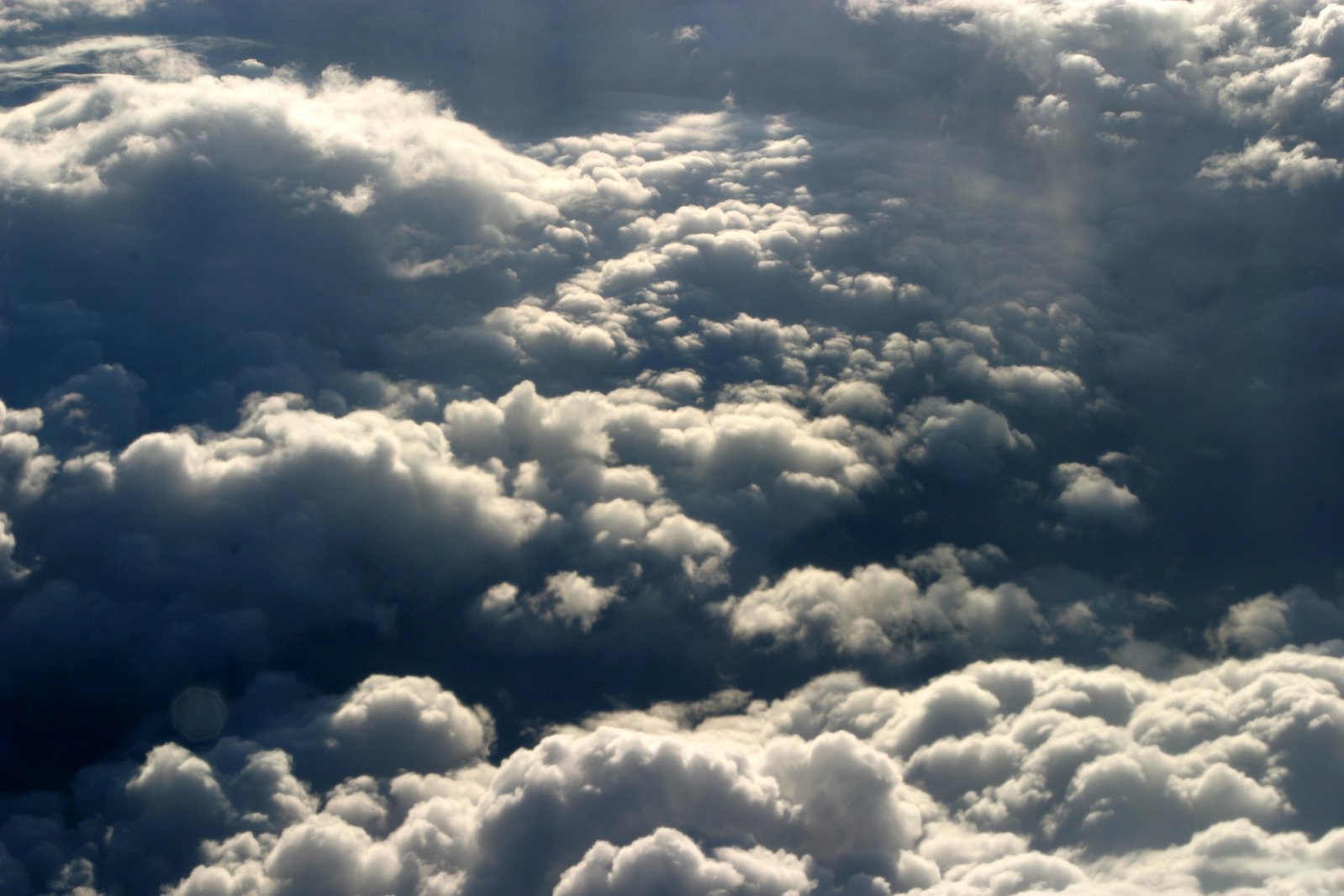 a plane flies through a very cloudy sky