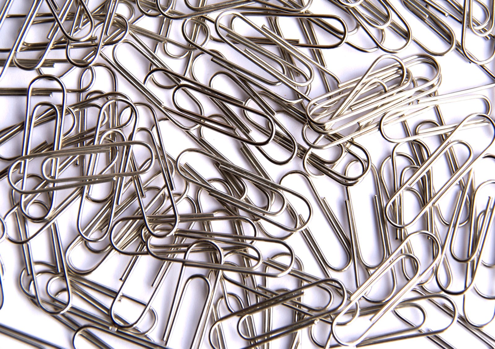 a bunch of small paper clips lying around on a table