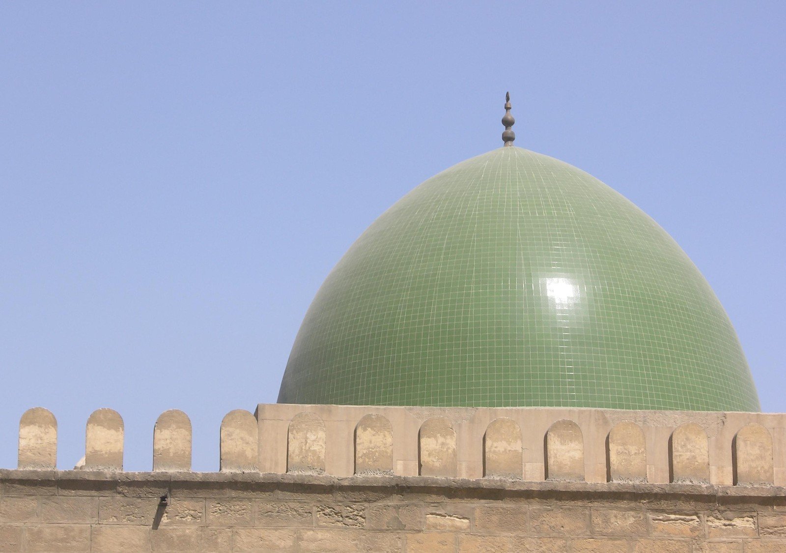 a green domed building with a light gray top