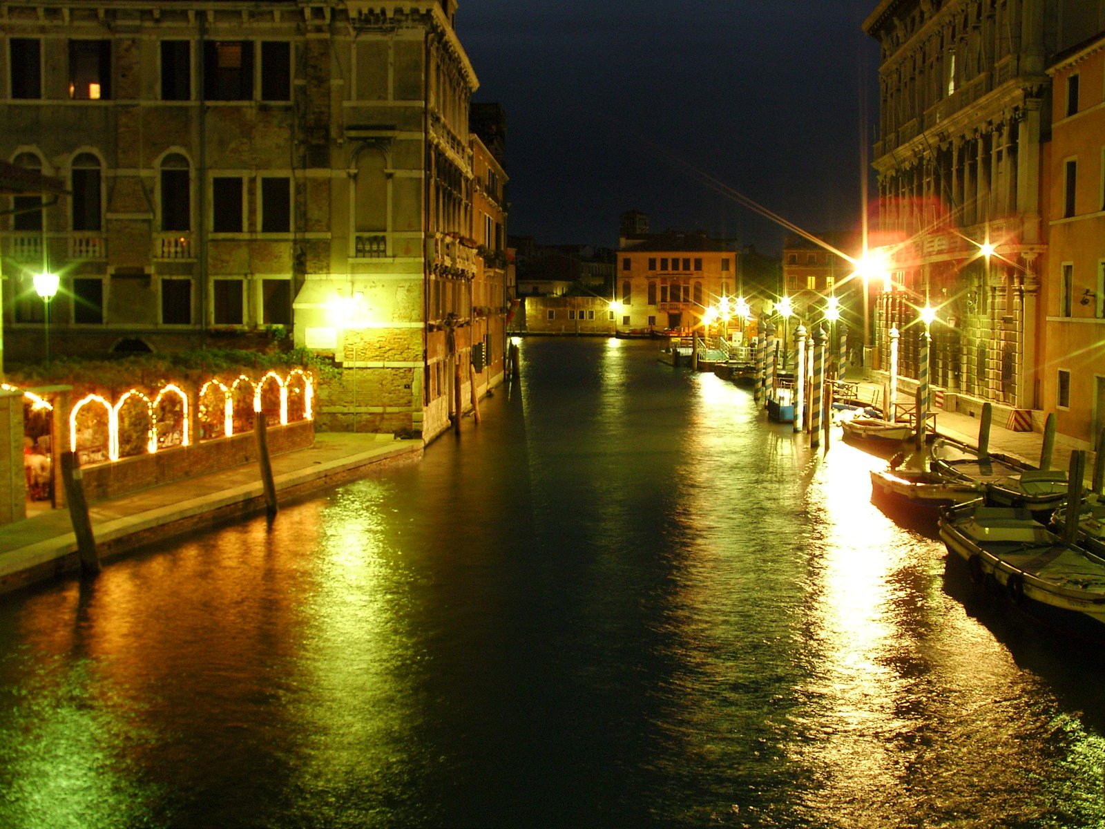 a long canal surrounded by brick buildings next to lights