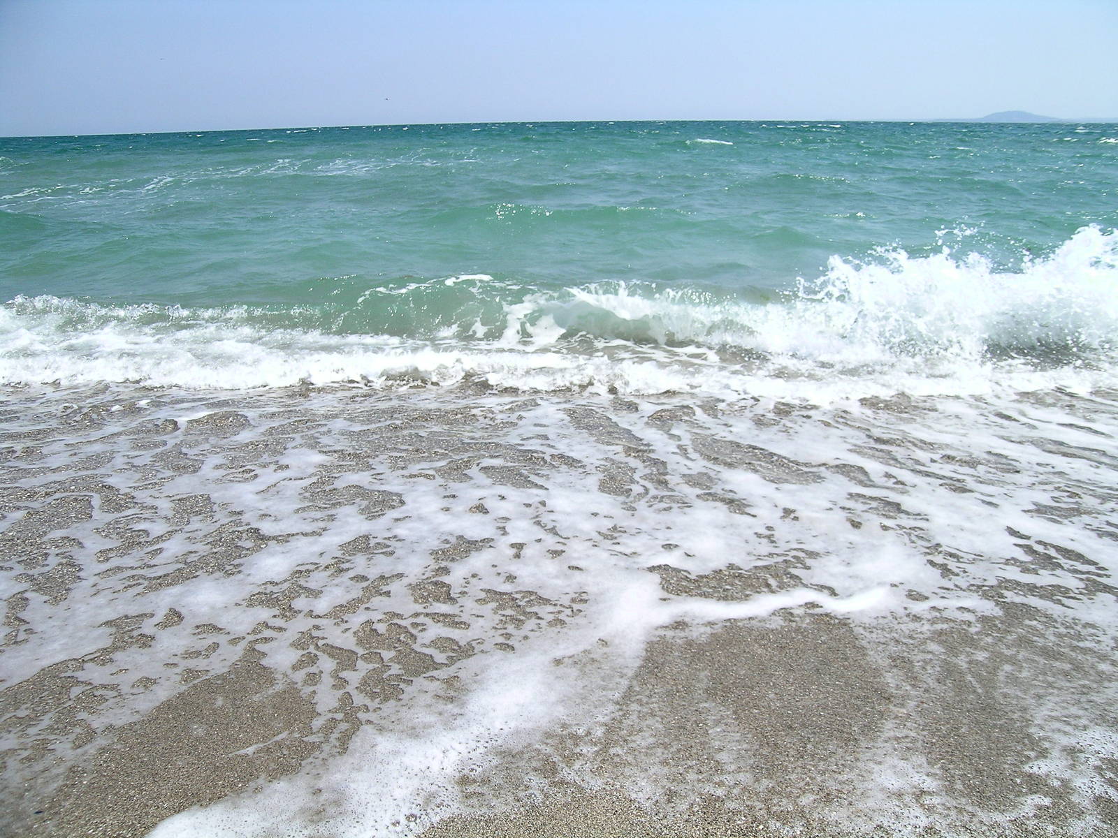 there is a sandy beach with waves coming in