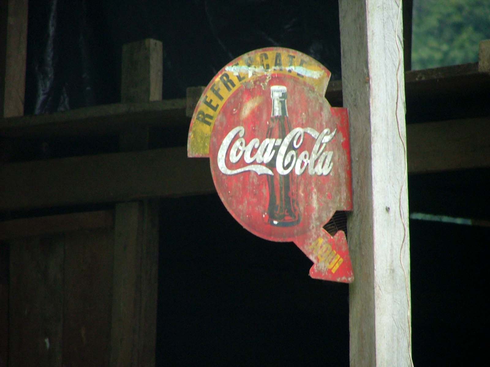a vintage coca cola advertit on a sign pole
