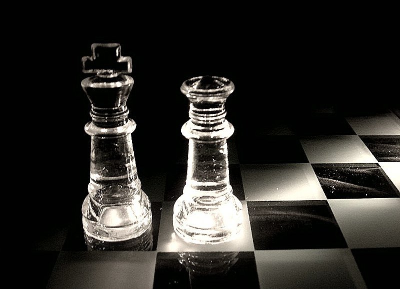 an image of glass chess pieces on a checkerboard background