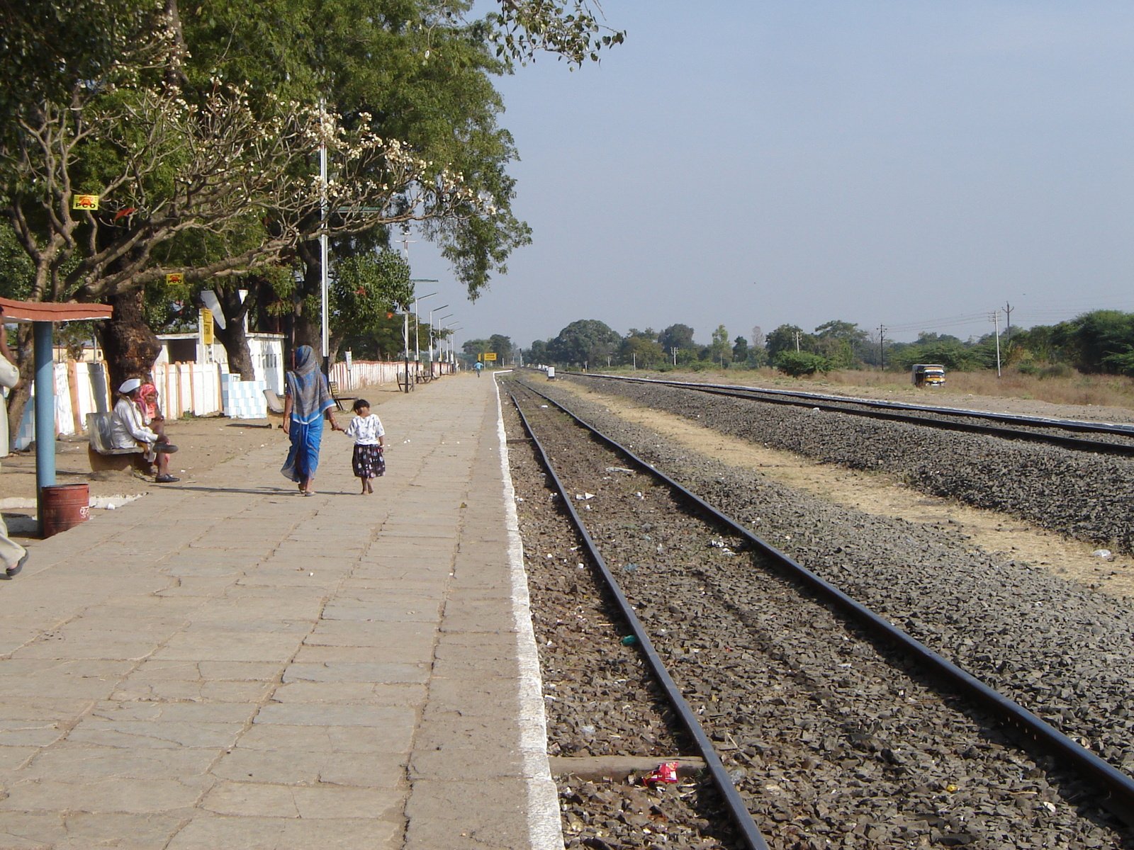 people walking along a train track past a rail line