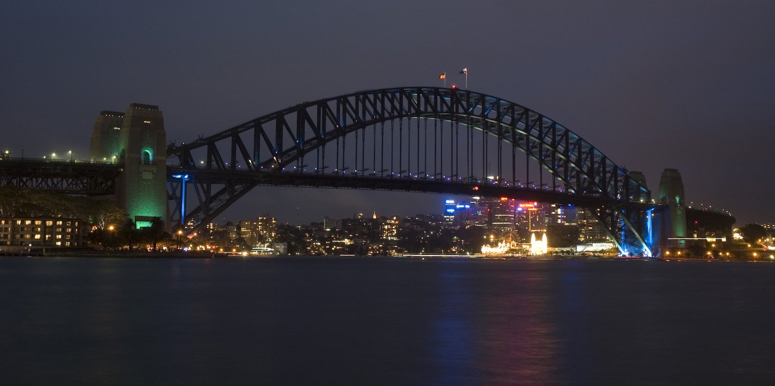 sydney skyline with the bridge lit up and over water