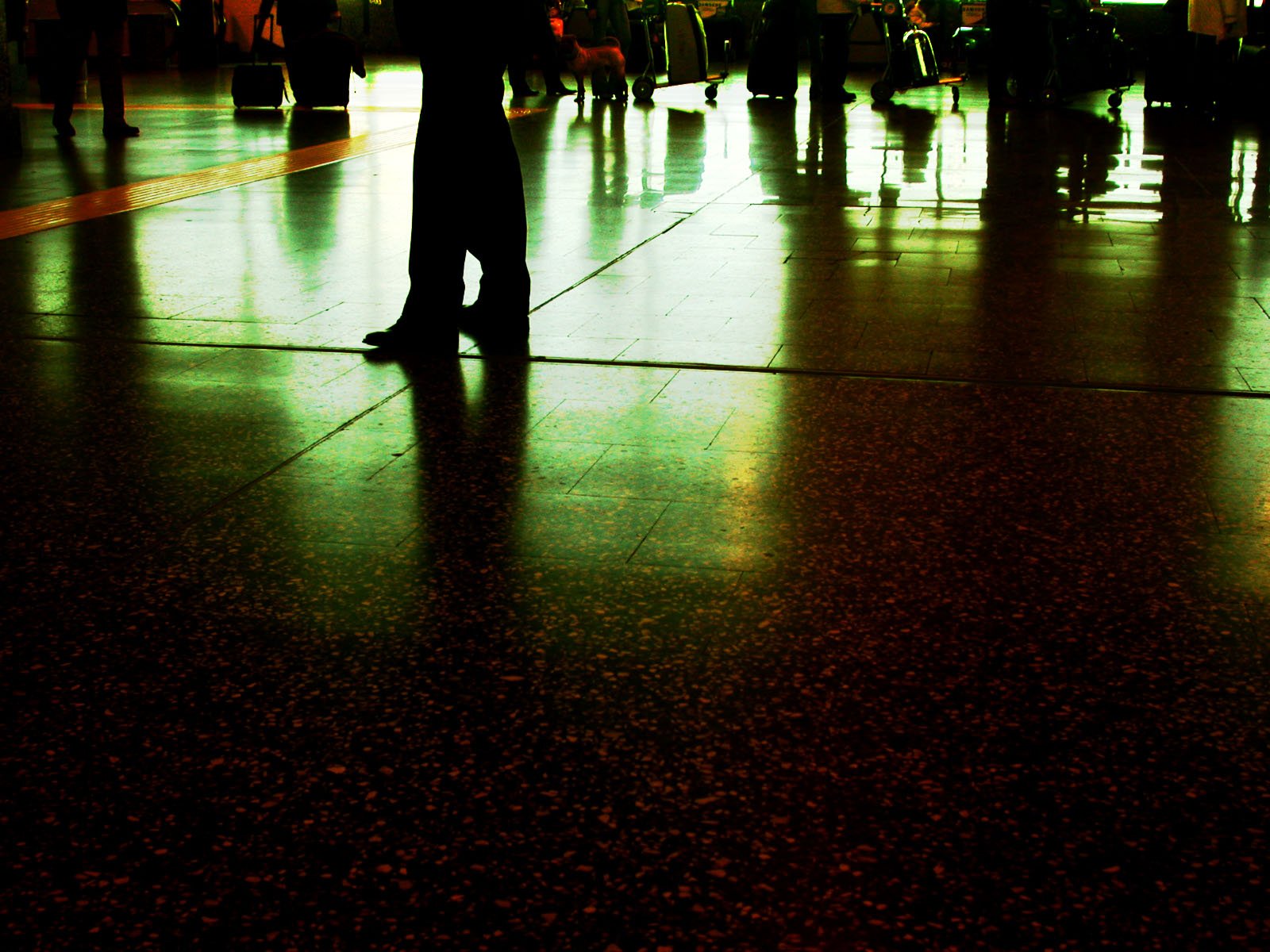 a man holding an umbrella walking in an airport