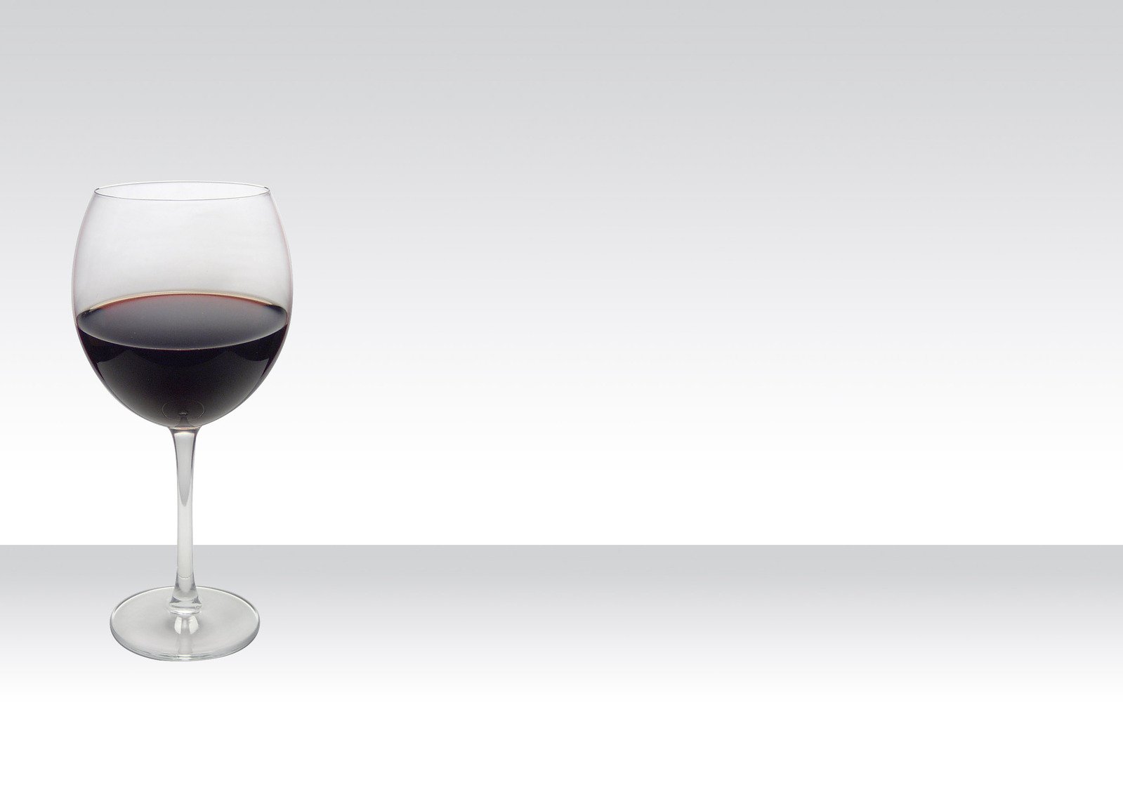 a glass of red wine is standing in the glass