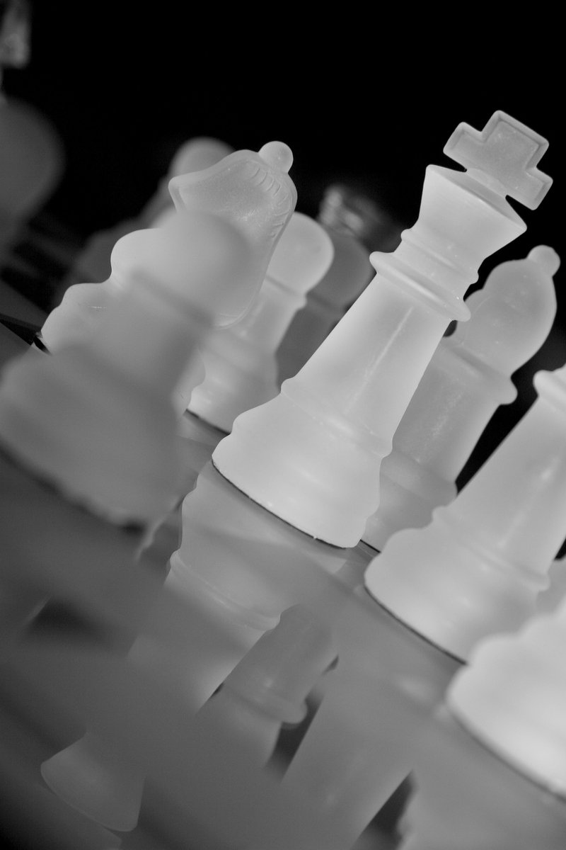 several clear plastic chess pieces are shown in black and white