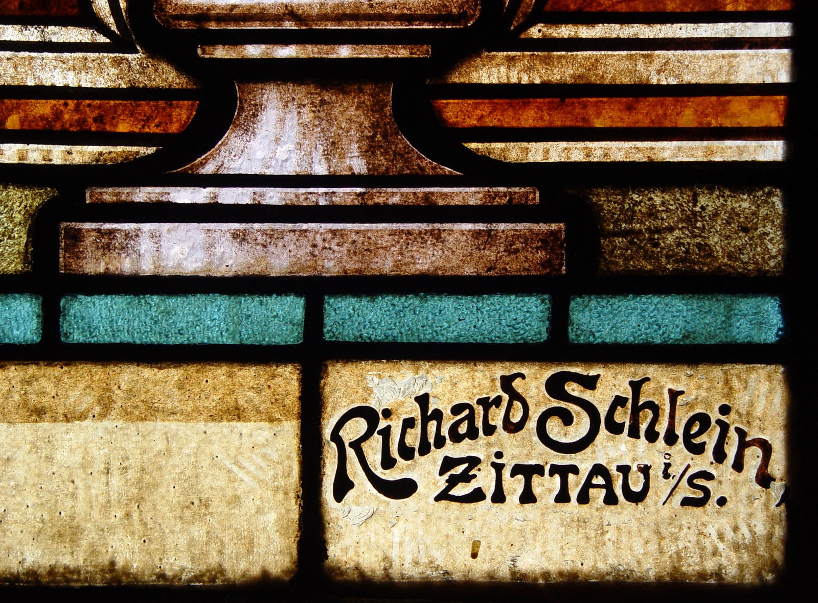 a glass showing the image of a cup in a stained glass window