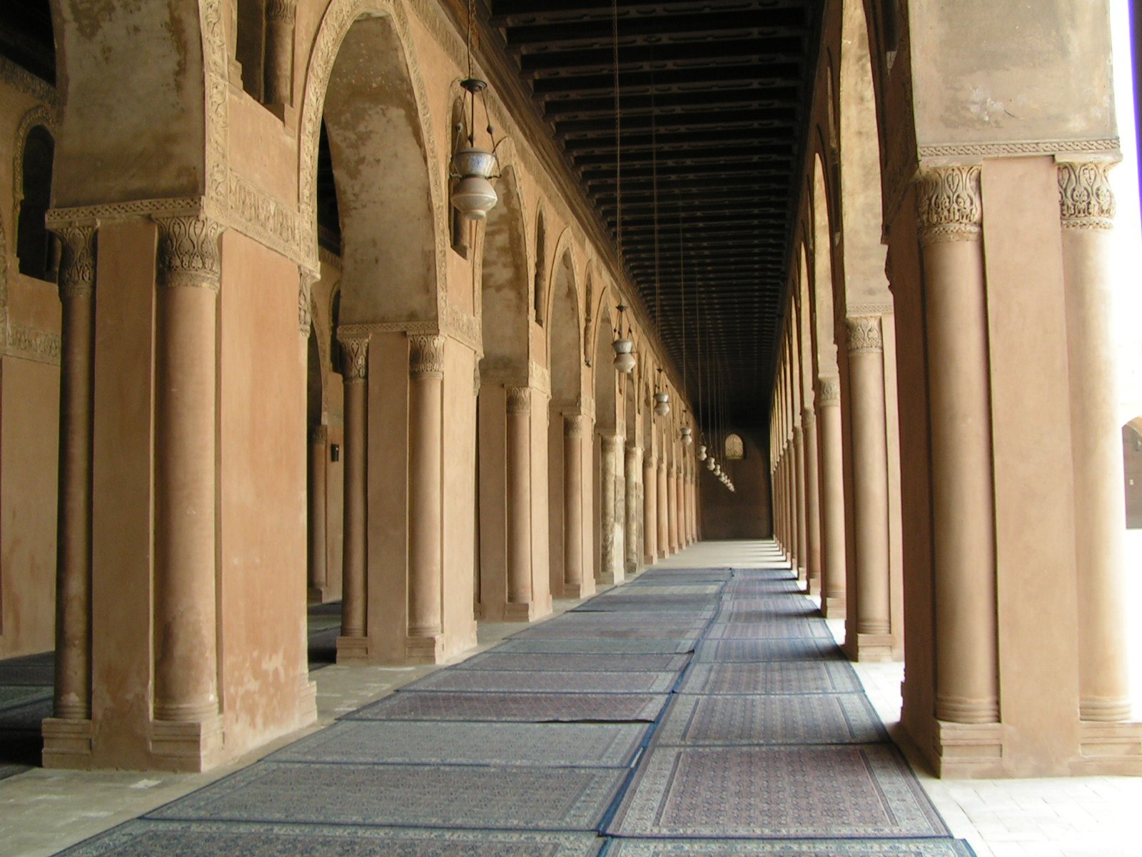 a corridor lined with tall columns under a ceiling