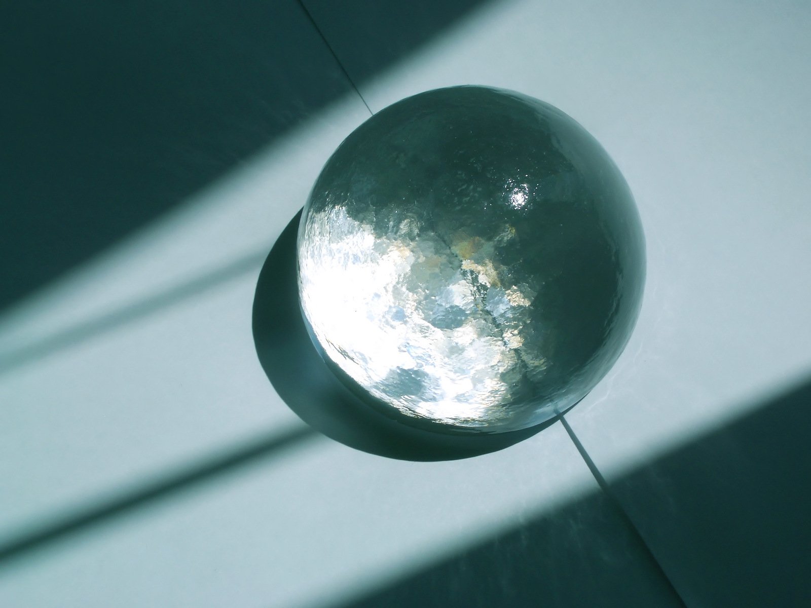 a sphere shaped object is casting a light shadow