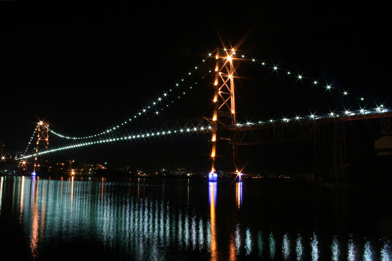 a large long bridge at night over water