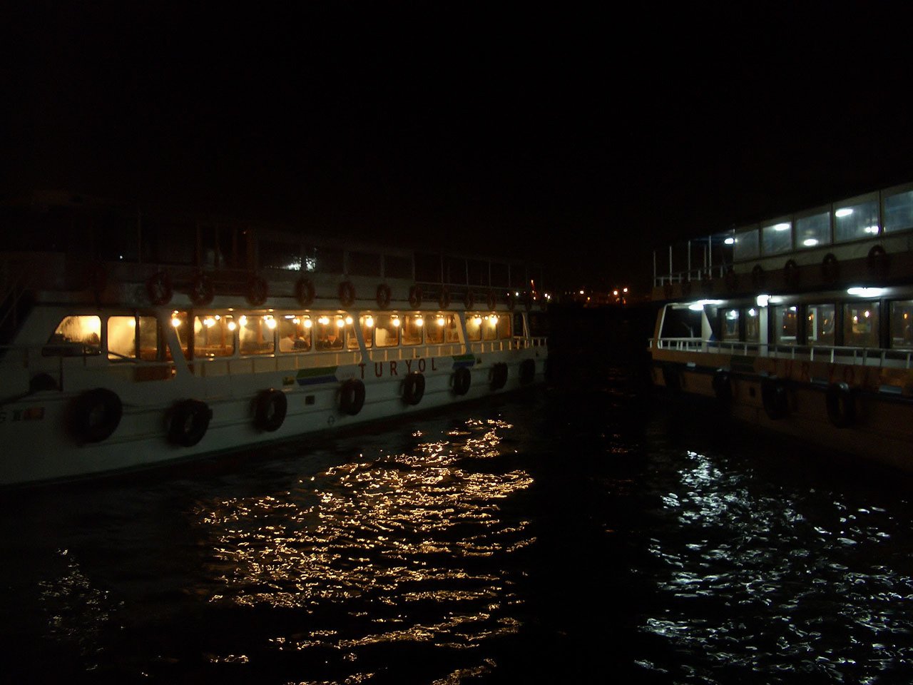 a white boat parked next to another boat on the water