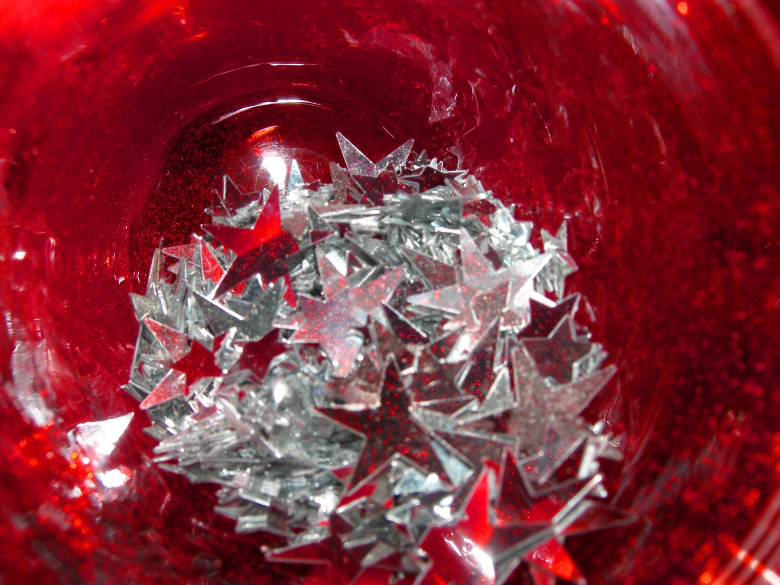 glass pieces in a red bowl next to a yellow object