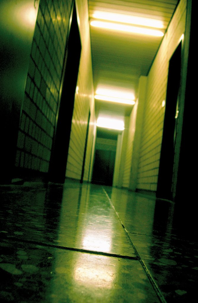 a hallway in a storage facility or office building with bright lighting shining through the window
