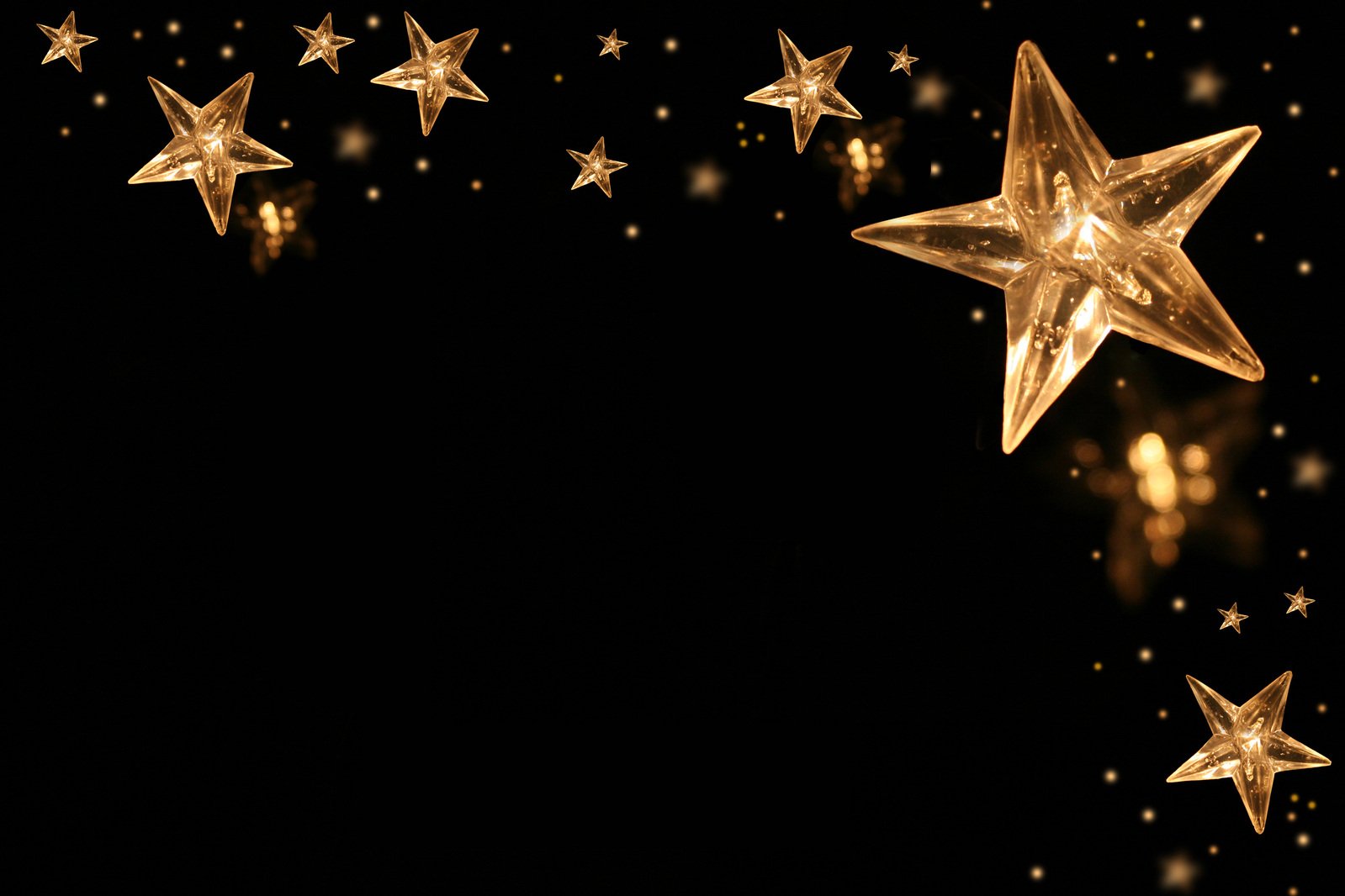 gold stars and stars falling out of the dark background