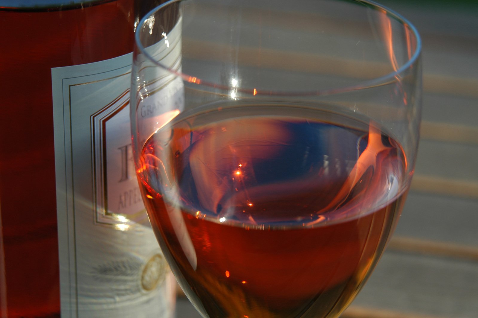 a glass of wine on a table next to a bottle