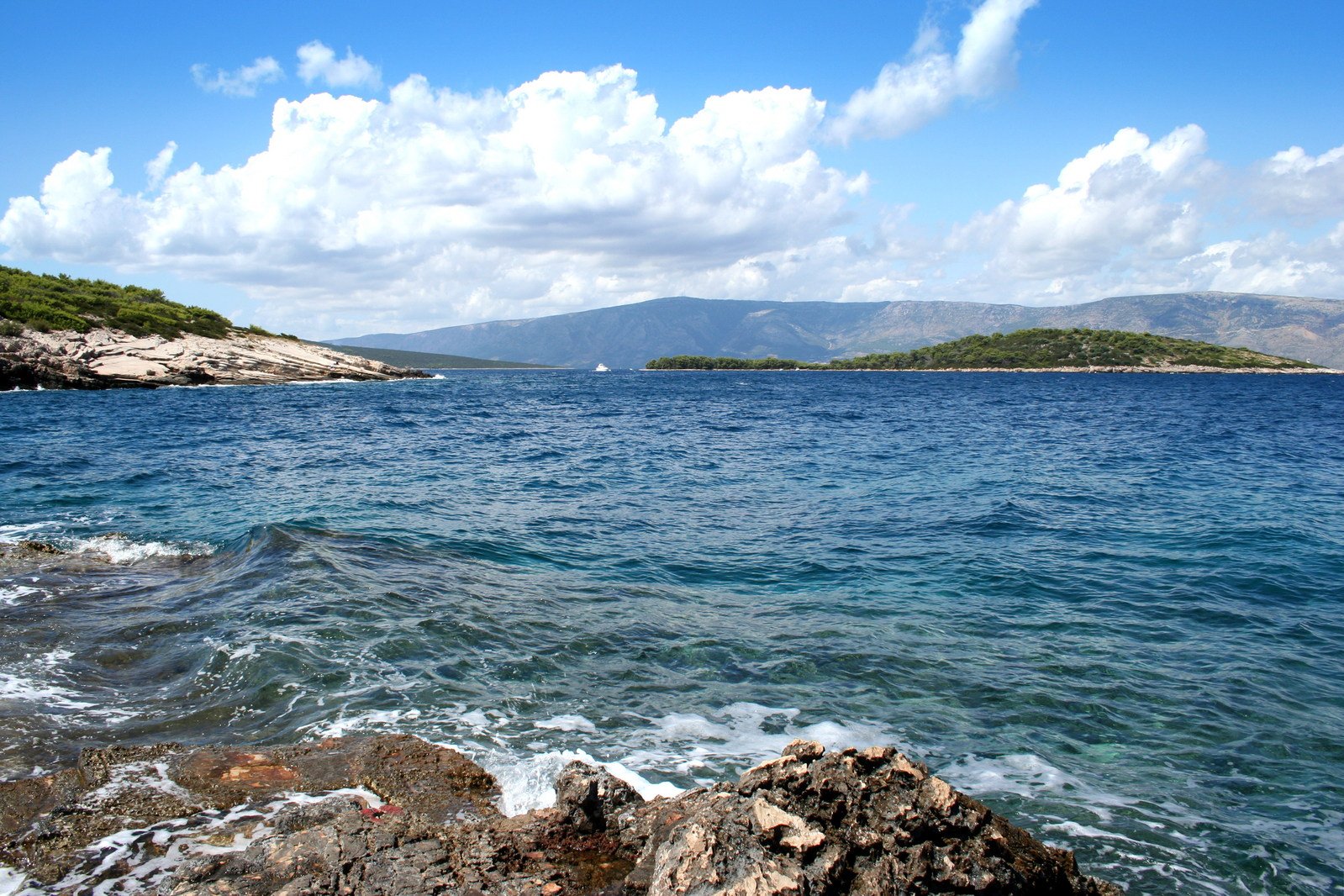 an ocean with lots of water, hills and small islands