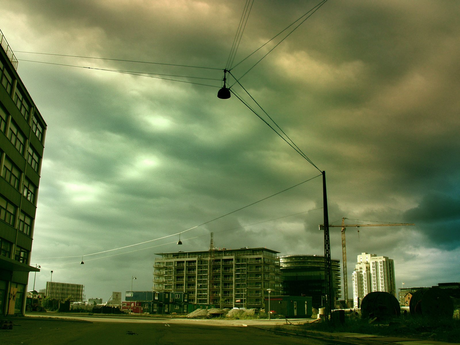 some power lines and some buildings against a cloudy sky