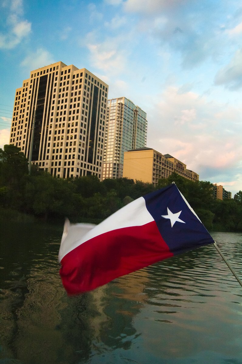 the flag flies high in the sky next to buildings