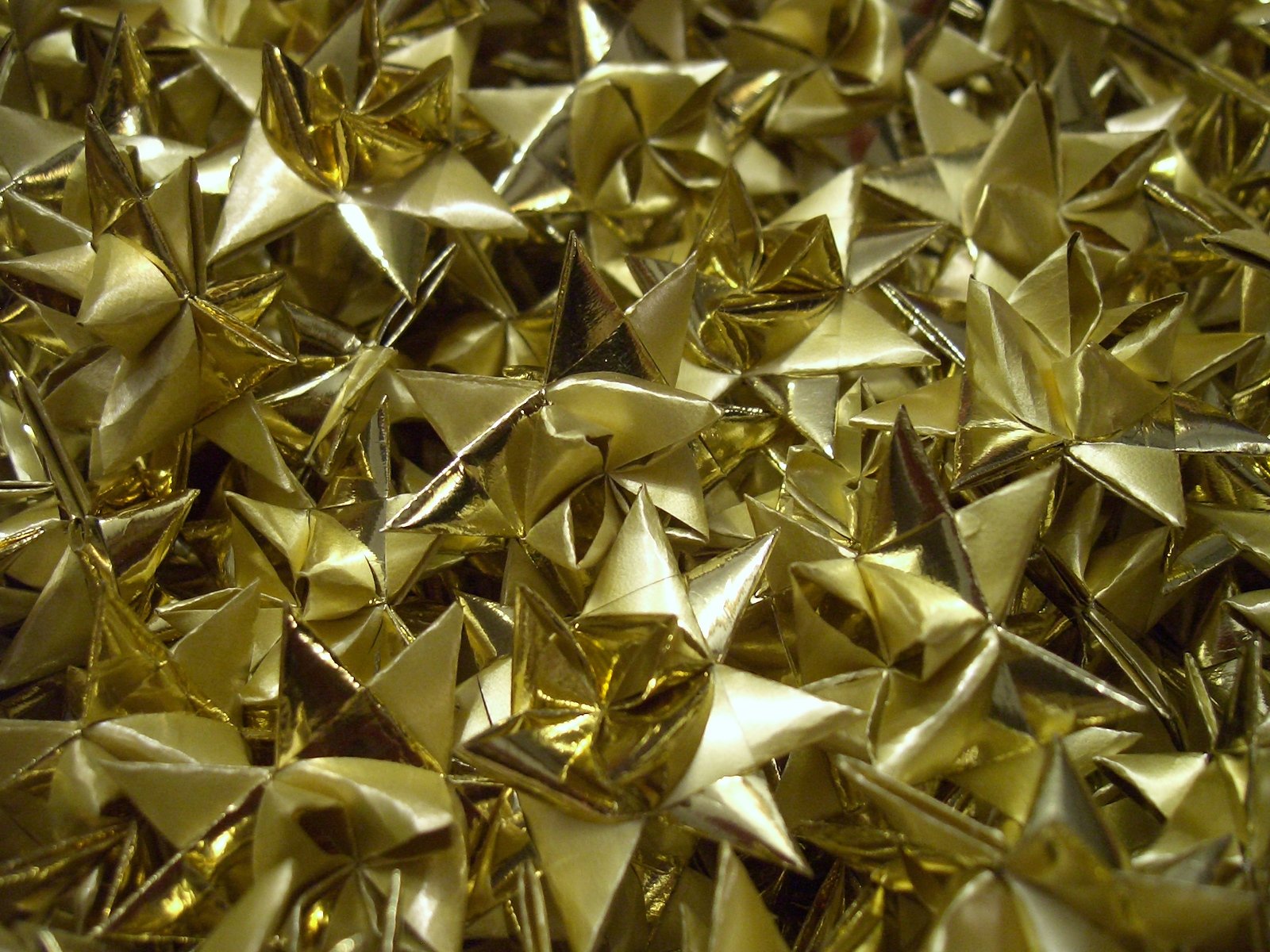 a lot of shiny metallic stars that are in a pile