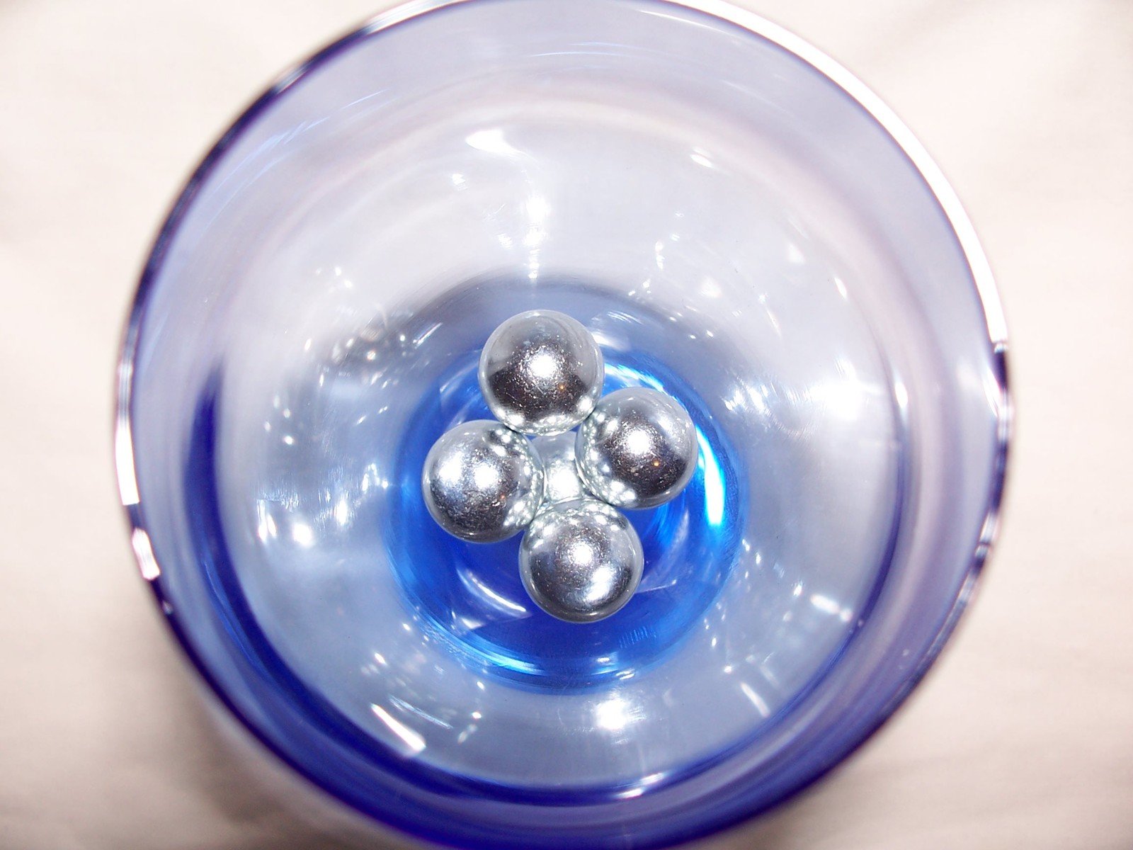 a clear bowl with silver balls in it