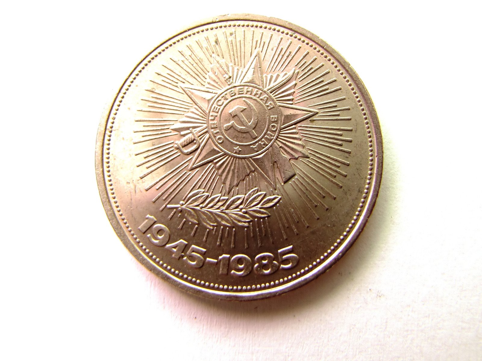 a gold sun and tree medal sitting on top of a table