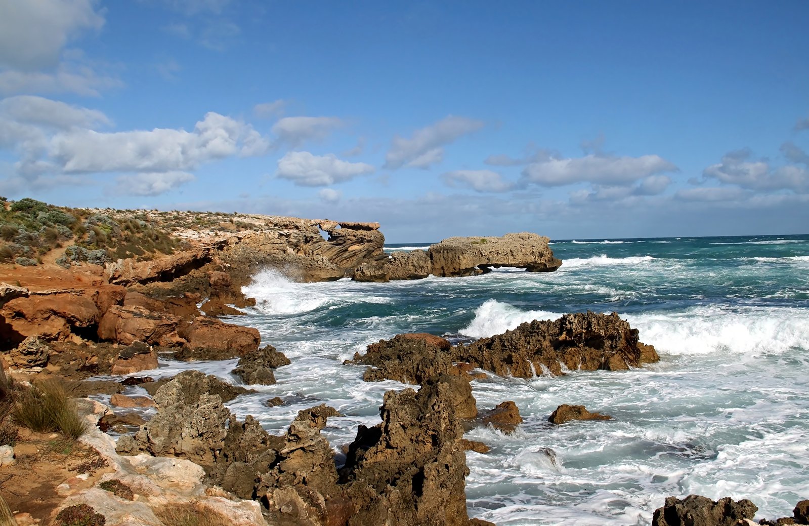 rocky coastline with ocean crashing into rocks